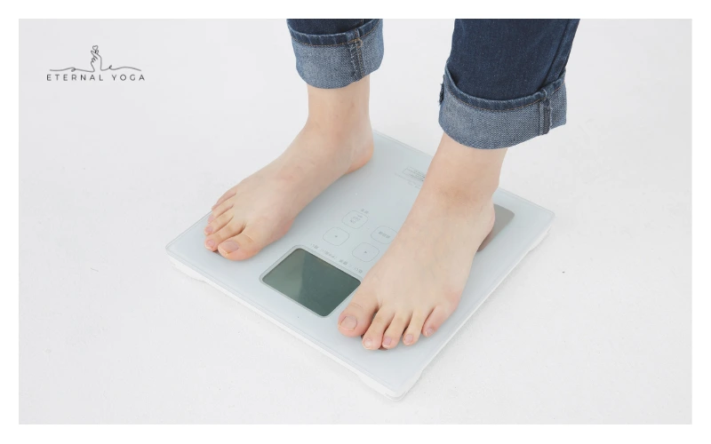 women on the weight machine measuring her weight after doing yoga