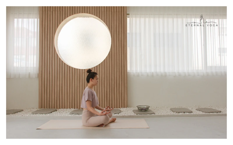 women doing yoga pose sitting in studio